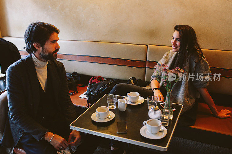 年轻人坐在柏林的一家咖啡馆里，喝着咖啡