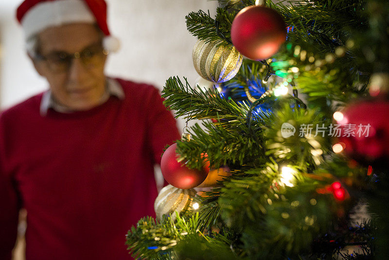 老人在装饰圣诞树。