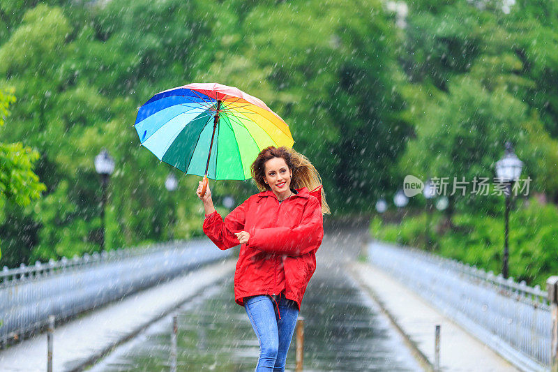 带着伞在雨天玩的女人