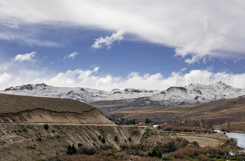 阿根廷里约热内卢Negro省的利美河与彩色的树木，天空与云彩和山与雪的背景