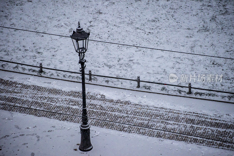 德国德累斯顿白雪覆盖的街道、灯柱和电车轨道。