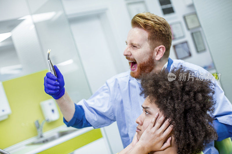 牙医兴高采烈地拿着一颗从创伤病人身上成功取出的牙齿