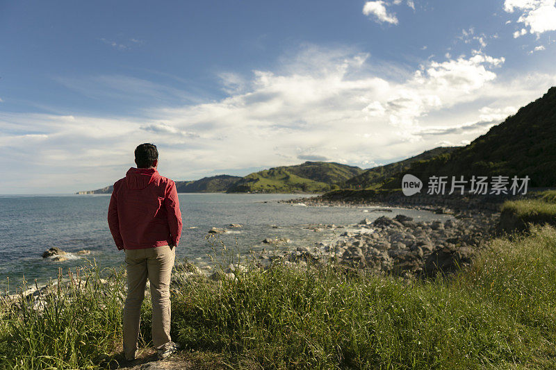 一位年轻人正在新西兰凯库拉海滩上享受宁静的风景