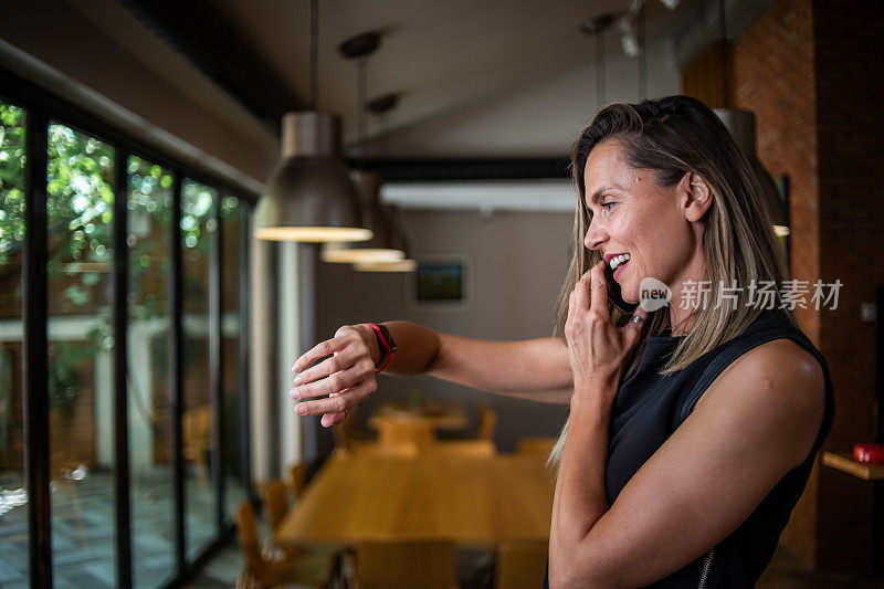 一位女商人站在餐厅里用手机