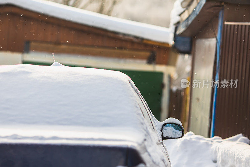 汽车镜子特写。雪下的汽车。冬天的天气。气候。风暴。运输
