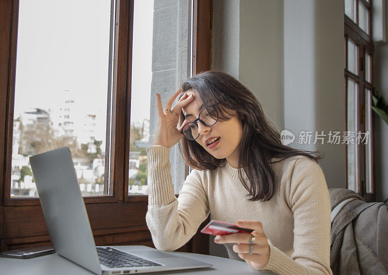 年轻女子用信用卡在电脑上购物