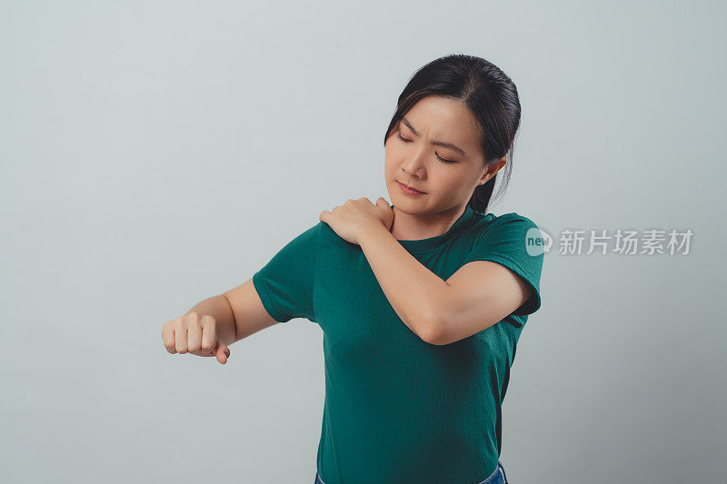 一名亚洲妇女肩痛，独自站立。