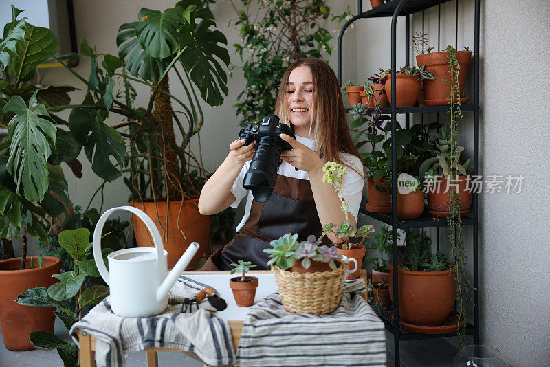 女摄影师用相机给植物拍照。