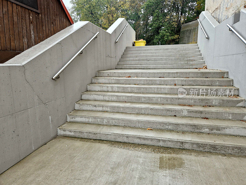 楼梯:公共建筑中带有混凝土边的楼梯安全楼梯有两个扶手，其中一个在学校入口处为12岁以下的儿童降低了高度，砖，黑色，红色。伪造