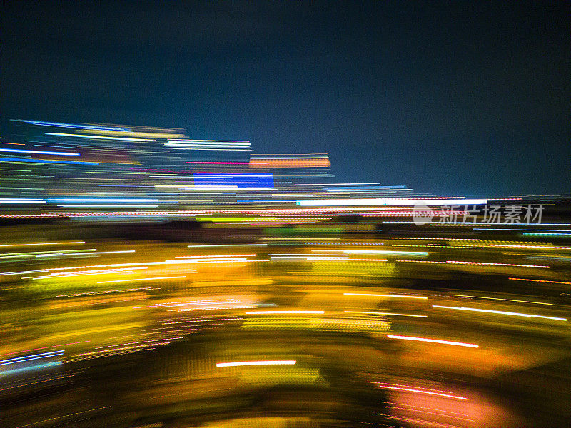 彩色的光线在夜间模糊地移动。亚特兰大市中心灯火通明。在长时间曝光中抽象出闪亮的线条