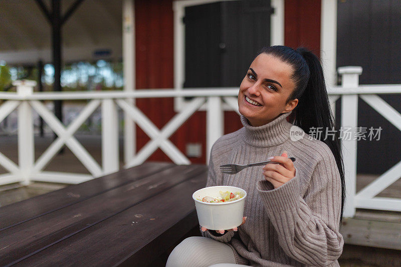 年轻女子在户外吃饭