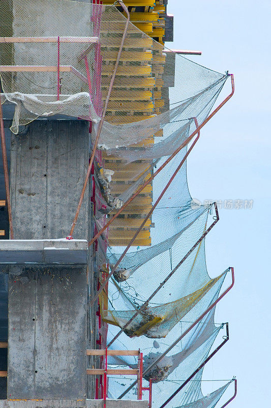 正在建造的建筑物上的保护性抓网。垂直框架