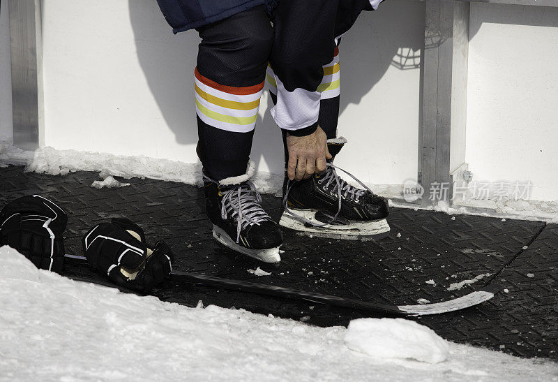 在户外打冰球前系好冰鞋的鞋带