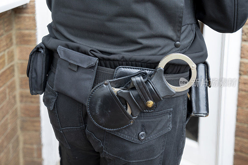 一件警察制服外套的特写，上面有明显的腰带和手铐