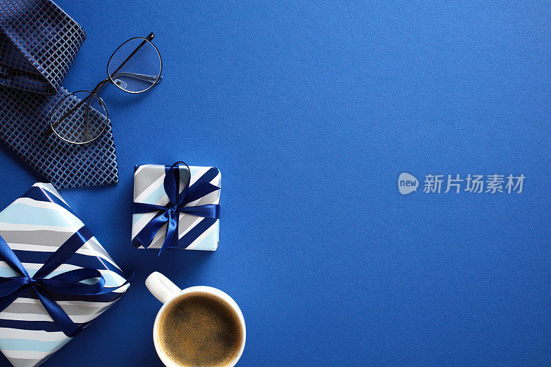 极简主义的公寓躺在蓝色背景的礼物，咖啡，领带，眼镜-理想的庆祝父亲节的主题