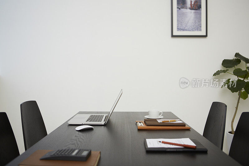 会议桌上有笔记本电脑、笔记本电脑和咖啡杯