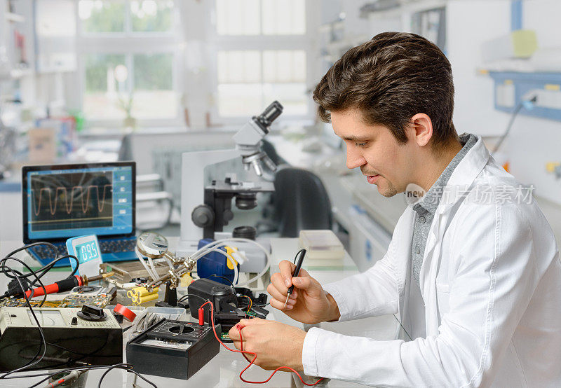 年轻男性技术人员或工程师正在修理电子设备