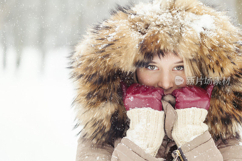 一个年轻的金发女人在外面下雪的肖像