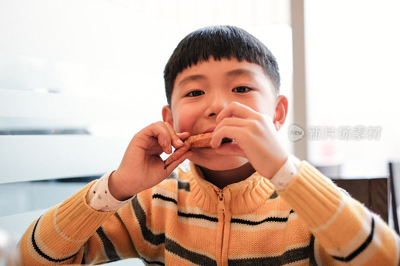 一个亚洲男孩在餐厅吃午饭