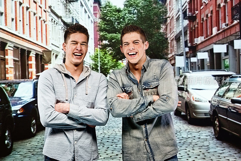 两个男孩一起站在城市的街道上