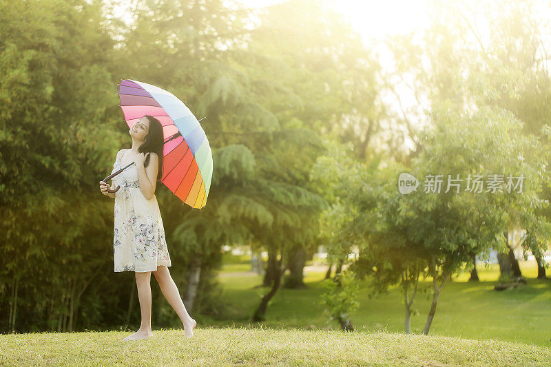 拿着白伞的女人站在田野里