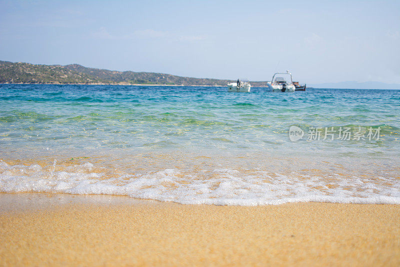 海滩上的海浪和模糊的摩托艇在背景中