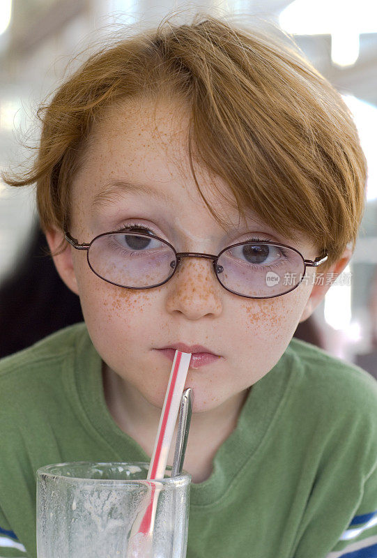 男孩和眼镜，儿童在餐厅喝巧克力奶昔