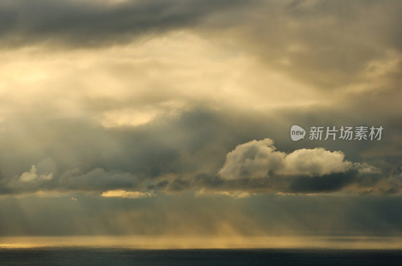 阳光在多云的天空在海上