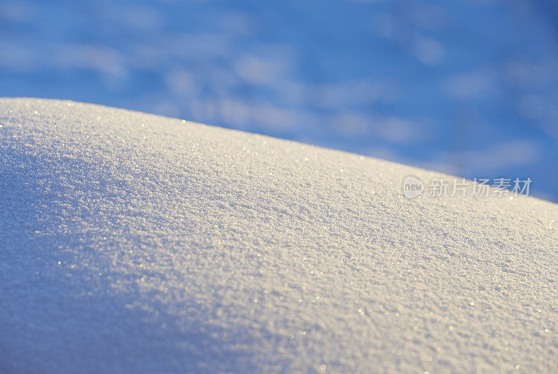 柔和的雪在温暖的光线下弯曲