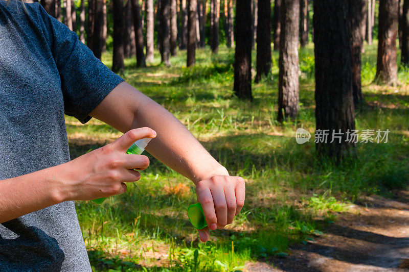 森林里的女孩用喷雾剂对付蚊子