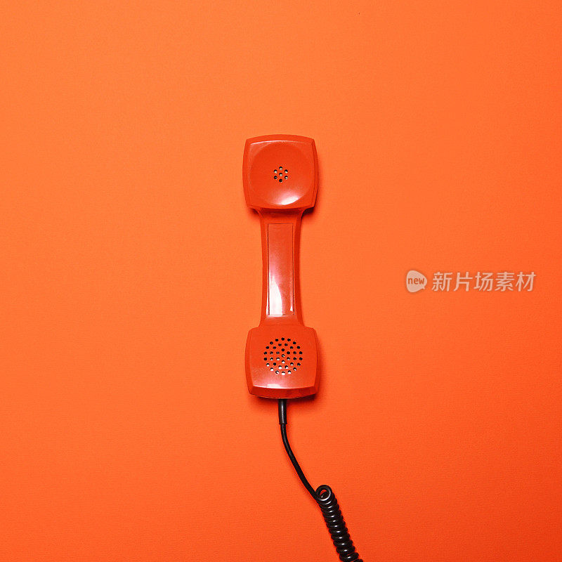 橙色背景上的复古橙色电话管-平铺