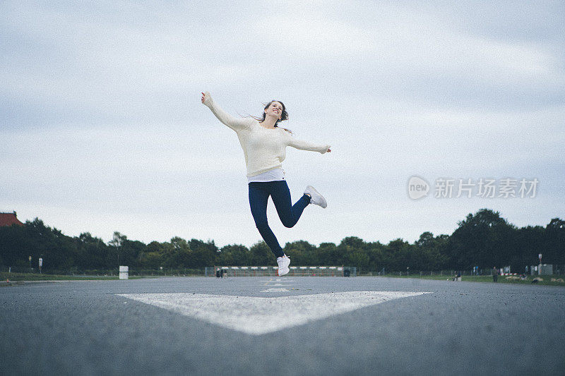 年轻的金发女子跳得比箭还高