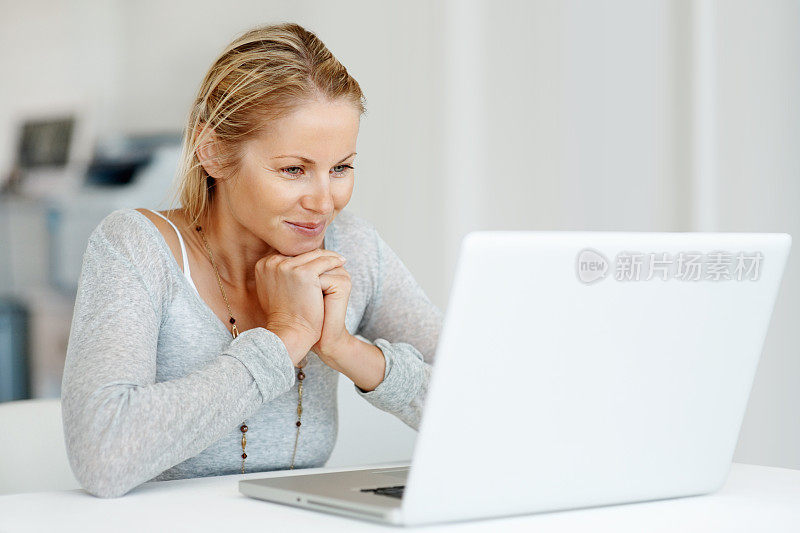 快乐的女人在家里使用笔记本电脑