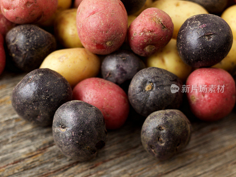 生的多色小土豆在木头表面