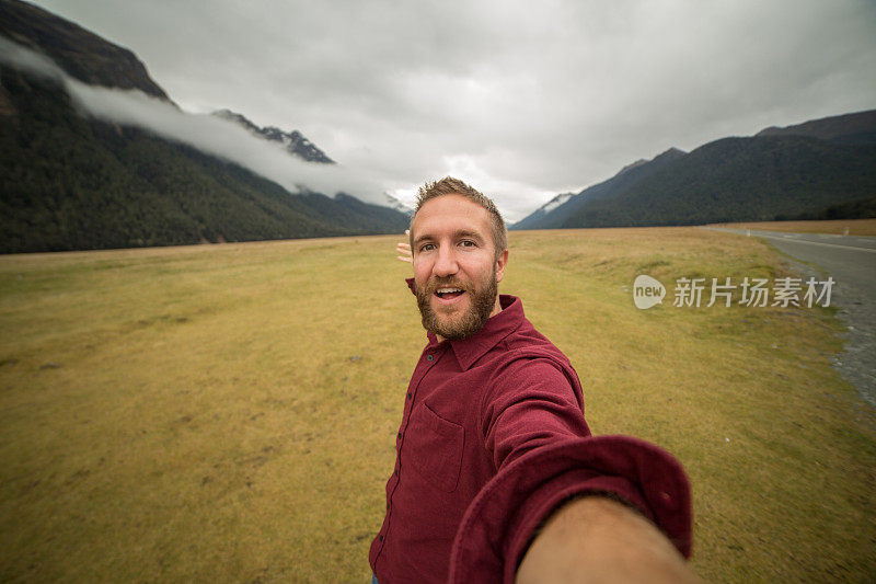 一名白人男性在旅行中与山景自拍