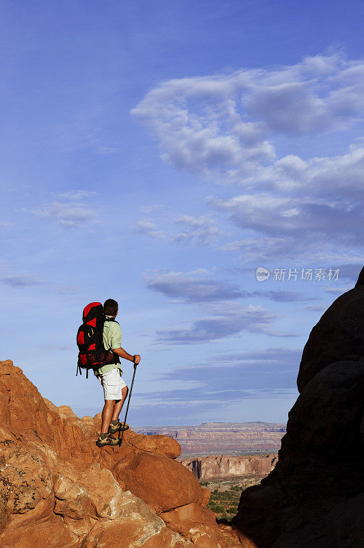 男徒步者站在岩石上看壮观的景色