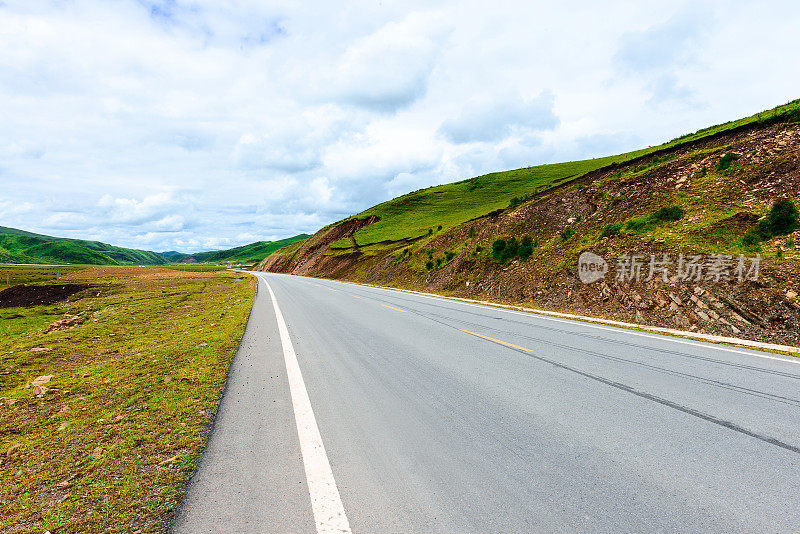 西藏高原的道路、草地和天空