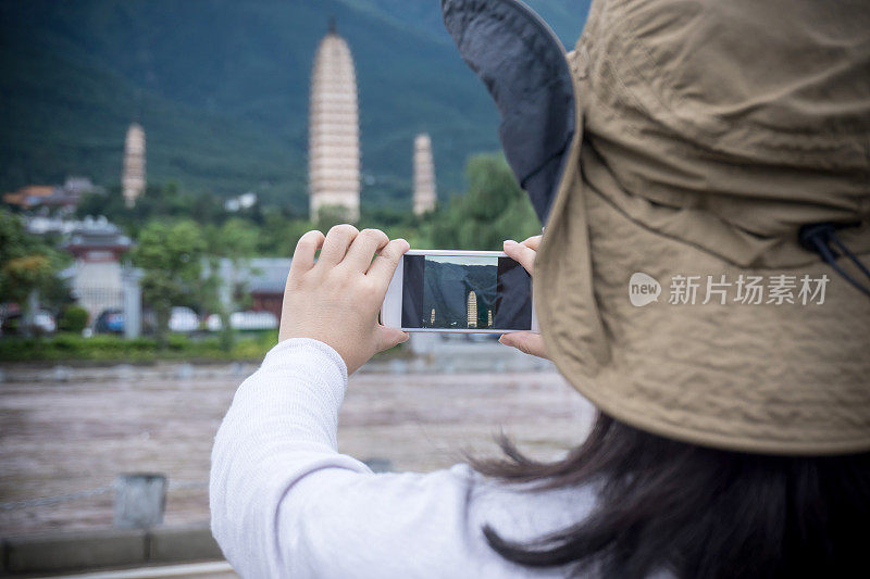 美丽的女人在拍照的三塔在中国