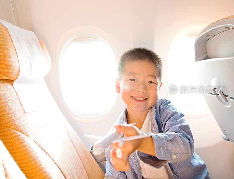 亚洲小男孩在玩玩具飞机