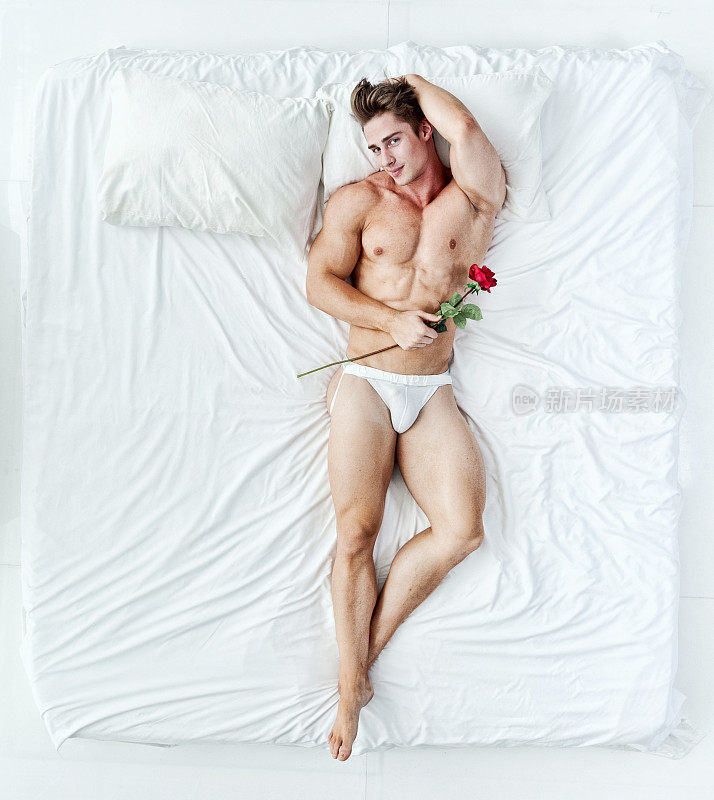 上图是肌肉发达的男子和玫瑰躺在床上