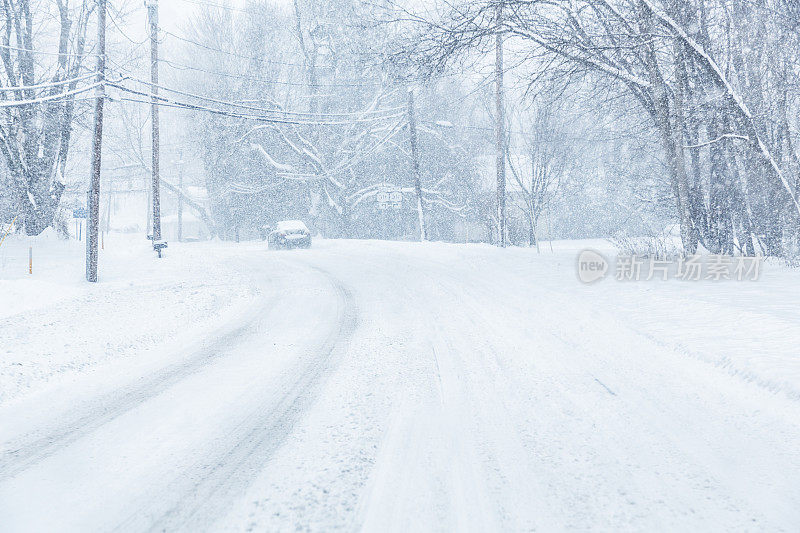 暴风雪期间，汽车在郊区道路弯道上行驶