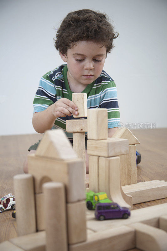 小男孩玩积木和汽车