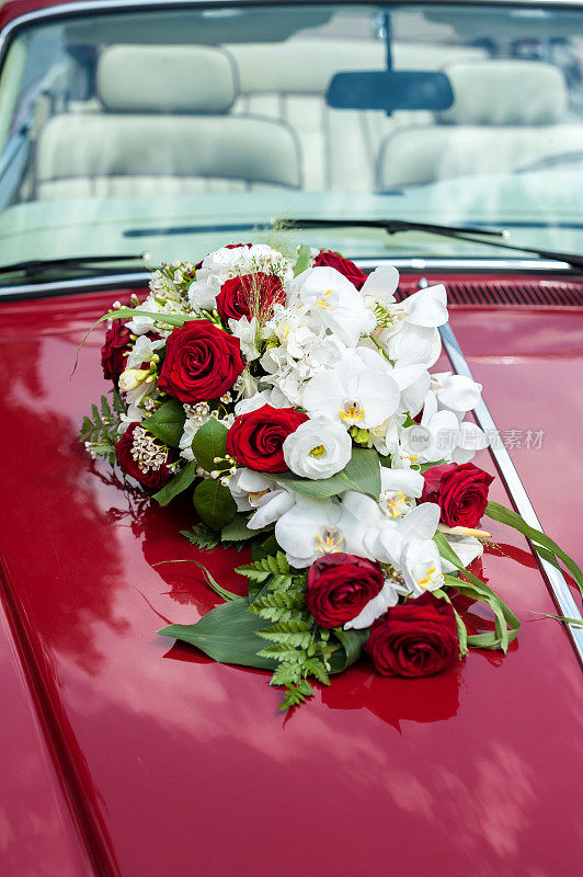 红色轿车上的婚礼花卉装饰