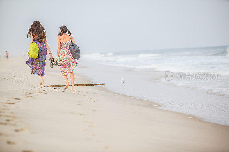 日落时分，两个女孩在琼斯海滩散步
