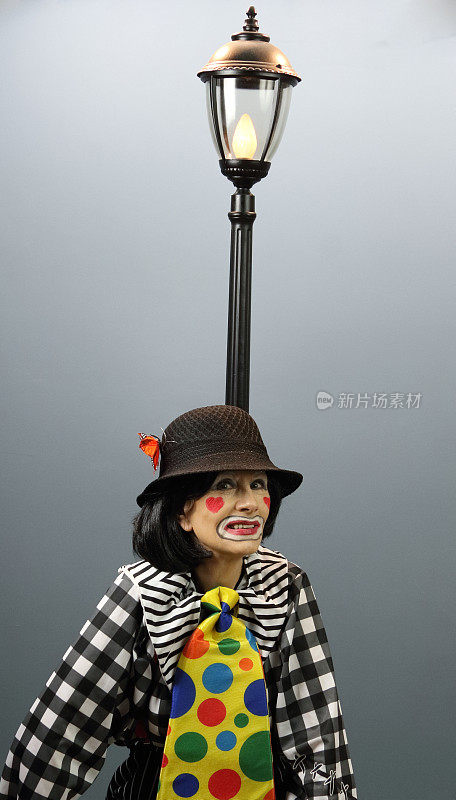 坐在街灯旁的女小丑