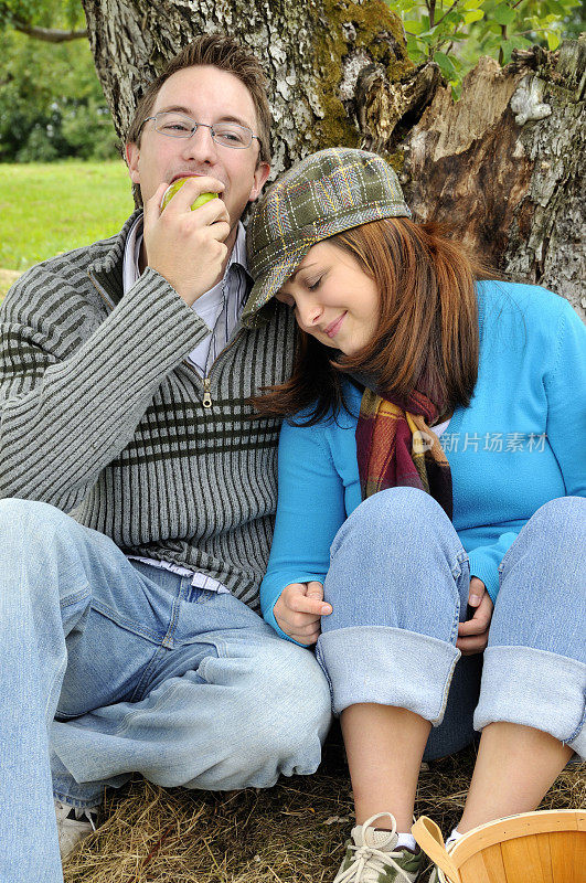 摘苹果的夫妇在树下休息