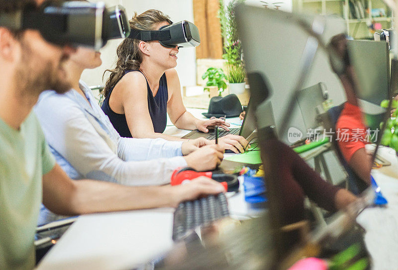 年轻学生在创意大学办公室使用虚拟现实眼镜-年轻人使用新技术-专注于最后的女性耳机-科技，创业，青年，未来和设计概念