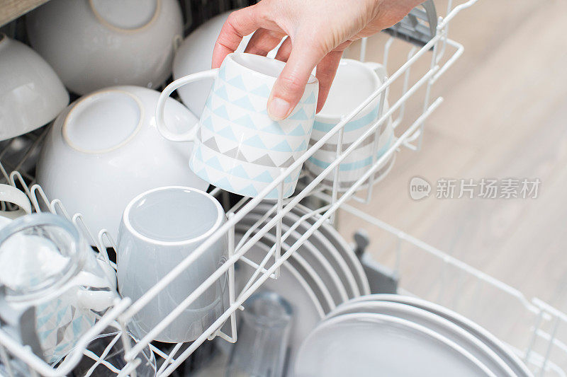 女人把陶器装进洗碗机的特写