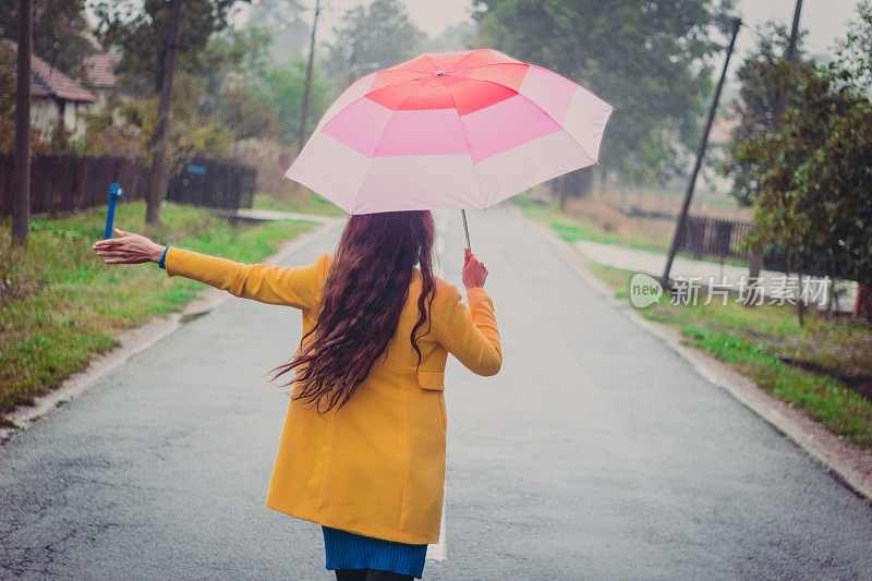 美丽的年轻女子享受着雨天