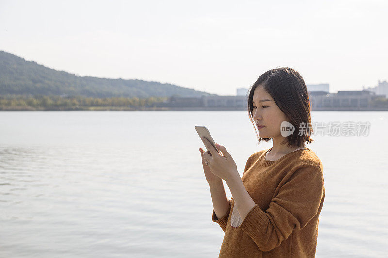 年轻女子在公园人行桥上发短信